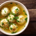 Servierte klassische Grießklößchensuppe in einer weißen Schüssel, garniert mit frischer Petersilie