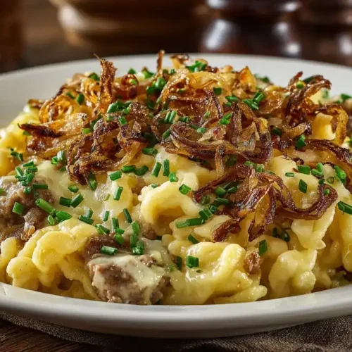 Käsespätzle Hackpfanne mit Lauch und knusprigen Röstzwiebeln auf Teller serviert