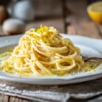 Cremige Spaghetti al Limone mit frischem Zitronenabrieb und Parmesan auf weißem Teller