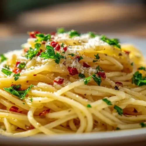 Spaghetti Aglio e Olio mit Knoblauch, Petersilie und Parmesan, serviert auf rustikalem Teller