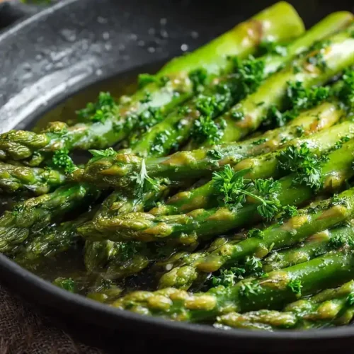 Knackiger grüner Spargel in der Pfanne mit Knoblauch und Petersilie, frisch zubereitet
