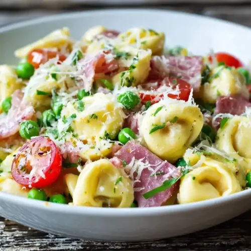 Cremiger Tortellini-Salat mit Schinken, Salami und Parmesan in Schüssel serviert