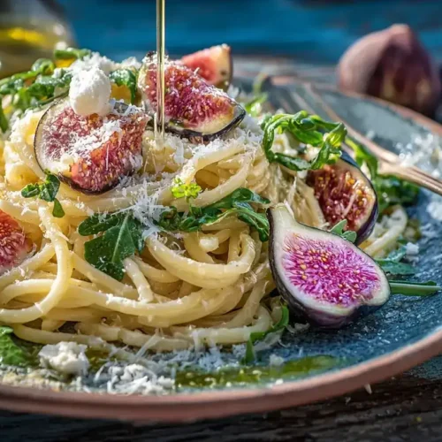 Mediterrane Pasta mit Rucola, frischen Feigen und Myzithra auf einem Teller serviert