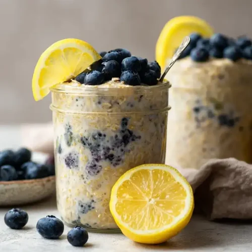 Cremige Zitronen-Blaubeer Overnight Oats auf rustikalem Holztisch, perfektes Frühstück