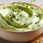 Cremiger Zucchini-Avocado-Aufstrich auf frischem Brot, serviert mit Kräutern