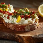 Cremige Feta-Olivencreme mit Paprika, garniert mit Oliven und Frühlingszwiebeln