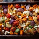 Herbstliches Ofengemüse mit Kürbis, Kartoffeln, Süßkartoffeln und Feta auf einem Backblech